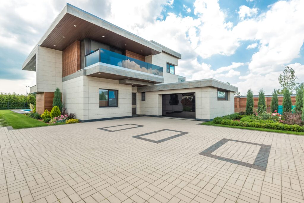 pexels-photo-8134845-8134845 Elegant modern house exterior with lush greenery and ample driveway space.